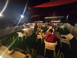 a group of people sitting at tables on a patio at night at Dumbara Peak Residence in Kandy