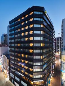 um edifício de escritórios preto alto com muitas janelas em Nine Tree Hotel Myeongdong em Seul