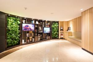 a large room with a tv and plants at Nine Tree Hotel Myeongdong in Seoul