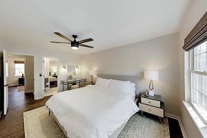 a bedroom with a white bed and a ceiling fan at Hunter's Terrace in Charleston