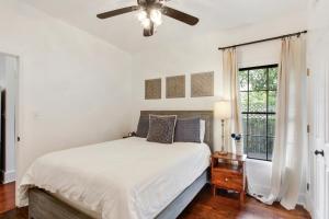 biała sypialnia z łóżkiem i wentylatorem sufitowym w obiekcie Duffy Lane w mieście Savannah