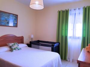 1 dormitorio con 2 camas y una ventana con cortinas verdes en Aloe Vera Beach, Dúplex 1ª Línea de Mar, en Caleta de Sebo