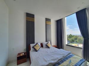 a bedroom with a bed and a large window at Song Anh Hotel in Buon Ma Thuot