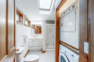 a bathroom with a toilet and a sink and a washing machine at Dream Harbor House and Cottage in Surry +22 photos