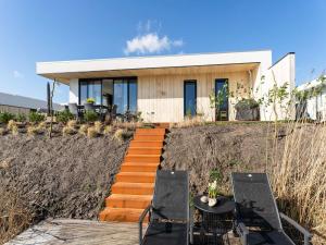 Family villa with garden and jetty في زيولْد: منزل على تلة مع كرسيين وطاولة