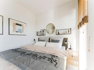 um quarto branco com uma cama grande e um espelho em Family villa with garden and jetty em Zeewolde
