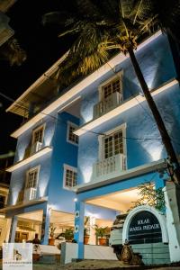 un edificio azul con una palmera delante de él en SOLAR MARIA PIEDADE, en Panaji
