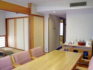 Habitación con mesa, sillas y cocina. en Hotel Laforet Shuzenji, en Izu