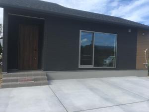 a black house with a door and a window at KAI Ichinomiya in Ichinomiya