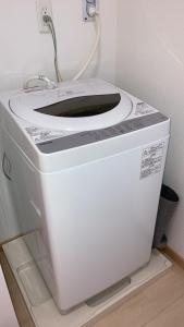 a white washer and dryer sitting in a room at KAI Ichinomiya in Ichinomiya