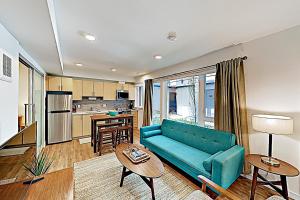 a living room with a blue couch and a kitchen at Atrium Unit 105 in Seattle