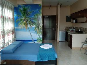a bedroom with a blue bed and a palm tree mural at Cebu City Suites Ramos Tower by P&J in Cebu City