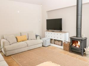 a living room with a couch and a fireplace at Fontburn Farmhouse in Morpeth
