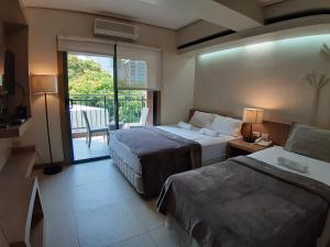a hotel room with two beds and a balcony at Cebu City Suites Ramos Tower by P&J in Cebu City