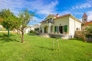 a large white house with a grass yard at Apartment Barbina Kaštelina in Sveti Juraj