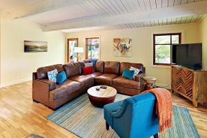 sala de estar con sofá de cuero y TV en Fletcher Bay Tranquility, en Fletcher Bay