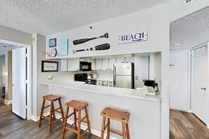 uma cozinha com um balcão e dois bancos em Kingston Plantation Unit 706 em Myrtle Beach