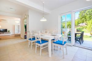 - une salle à manger blanche avec une table et des chaises blanches dans l'établissement Apartment Barbina Kaštelina, à Sveti Juraj
