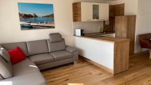 a living room with a couch and a kitchen at Pia am See - Bio Design Appartement in Bad Wiessee