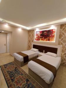 une chambre d'hôtel avec 2 lits et un tableau mural dans l'établissement La Boutique Residence, à Hurghada