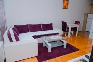 a living room with a white couch and a table at Apartman Luna lukavica in Lukavica