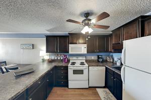 uma cozinha com um fogão branco e uma ventoinha de tecto em Long Bay Dunes D3 em Myrtle Beach
