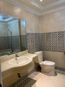 ein Badezimmer mit einem Waschbecken, einem WC und einem Spiegel in der Unterkunft I Travel Motel - II in Kaohsiung