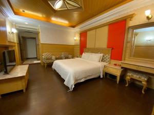 a bedroom with a large bed and a television at I Travel Motel - II in Kaohsiung