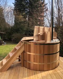 a wooden hot tub sitting on a wooden deck at Gite l'Ancolie in Marignier