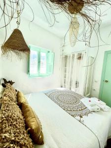 1 dormitorio con 1 cama con colcha blanca en Casa Bali. Duplex con terraza privada en centro, en Vejer de la Frontera