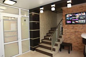 a staircase in a home with a tv on a brick wall at Amigo Hotel in Yekaterinburg