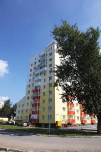 un edificio alto amarillo y rojo en una calle en Amigo Hotel, en Yekaterinburg