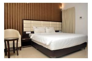 a bedroom with a large bed and a table at The Kings Park Residency in Chennai