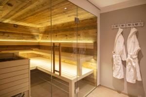 una sauna con paredes de madera y puertas de cristal en Hotel Berlin Tegernsee, en Rottach-Egern