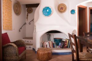 un soggiorno con camino, tavolo e sedie di La Casa dell'Artista a Orosei