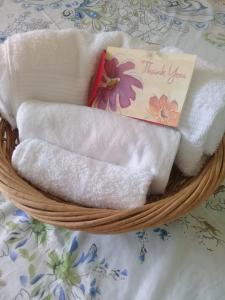 uma cesta cheia de toalhas com uma nota de agradecimento em Aruba Backpackers em Oranjestad