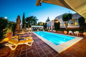 een zwembad met stoelen en een huis bij Hotel B&B Casa Arena Sevilla in Tomares