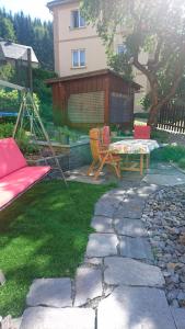 een patio met een schommel, een tafel en stoelen bij Ferienwohnung mit Garten und Spielplatz in Klingenthal +9 foto's