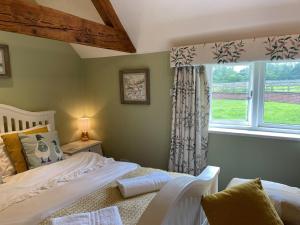a bedroom with a bed and a window at Idyllic Suite at Lower Fields Farm in Napton on the Hill