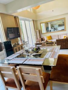 a living room with a glass table and chairs at Pico de Loro 2 BD Garden Loft with Lagoon View in Nasugbu