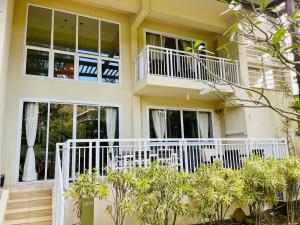 a house with a white railing and windows at Pico de Loro 2 BD Garden Loft with Lagoon View in Nasugbu