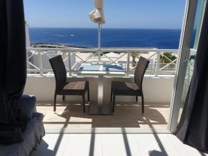 a table and chairs on a balcony with a view of the ocean at Las Terricitas Old town Apartment in Puerto del Carmen