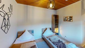 ein Schlafzimmer mit 2 Betten und einer Wand mit einem Hirschkopf an der Wand in der Unterkunft Ferienhaus Siesta Hahnenklee mit großem Grundstück in Hahnenklee-Bockswiese
