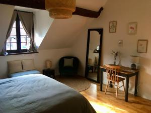1 dormitorio con 1 cama, 1 mesa y 1 silla en Le Clos des Noues, en Hermeray