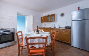a kitchen with a table and a stainless steel refrigerator at Awesome Home In Koromacno With Kitchen in Koromačno