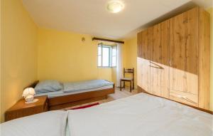 a bedroom with a bed and a wooden cabinet at Awesome Home In Koromacno With Kitchen in Koromačno