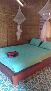 a bedroom with a bed with mosquito nets on it at Tereng Wilis bungalows in Tetebatu