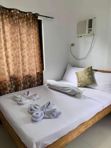 ein Schlafzimmer mit einem Bett mit Handtüchern darauf in der Unterkunft Sheryl May Inn in El Nido