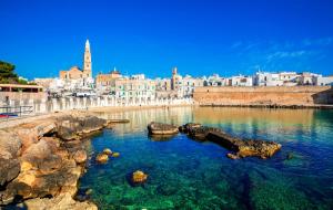 una gran masa de agua con una ciudad al fondo en Suite Terracielo, en Monopoli