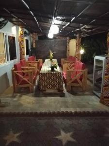 Residence Ivoire Cotonou في كوتونو: غرفة طعام مع طاولة وكراسي حمراء